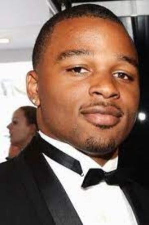 Keenan Coogler posing for a photoshoot by wearing black suit.